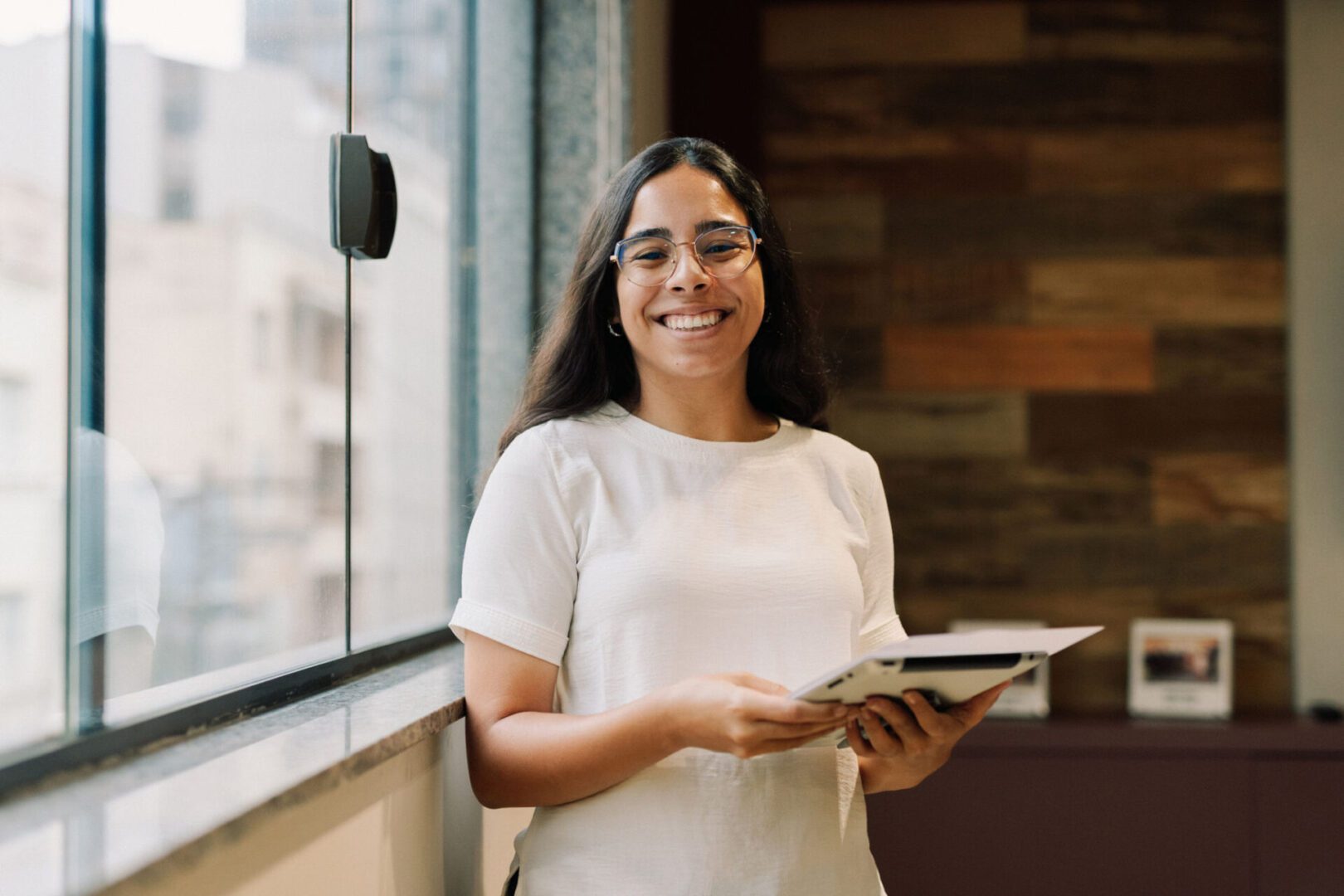 Happy woman standing indoors with book