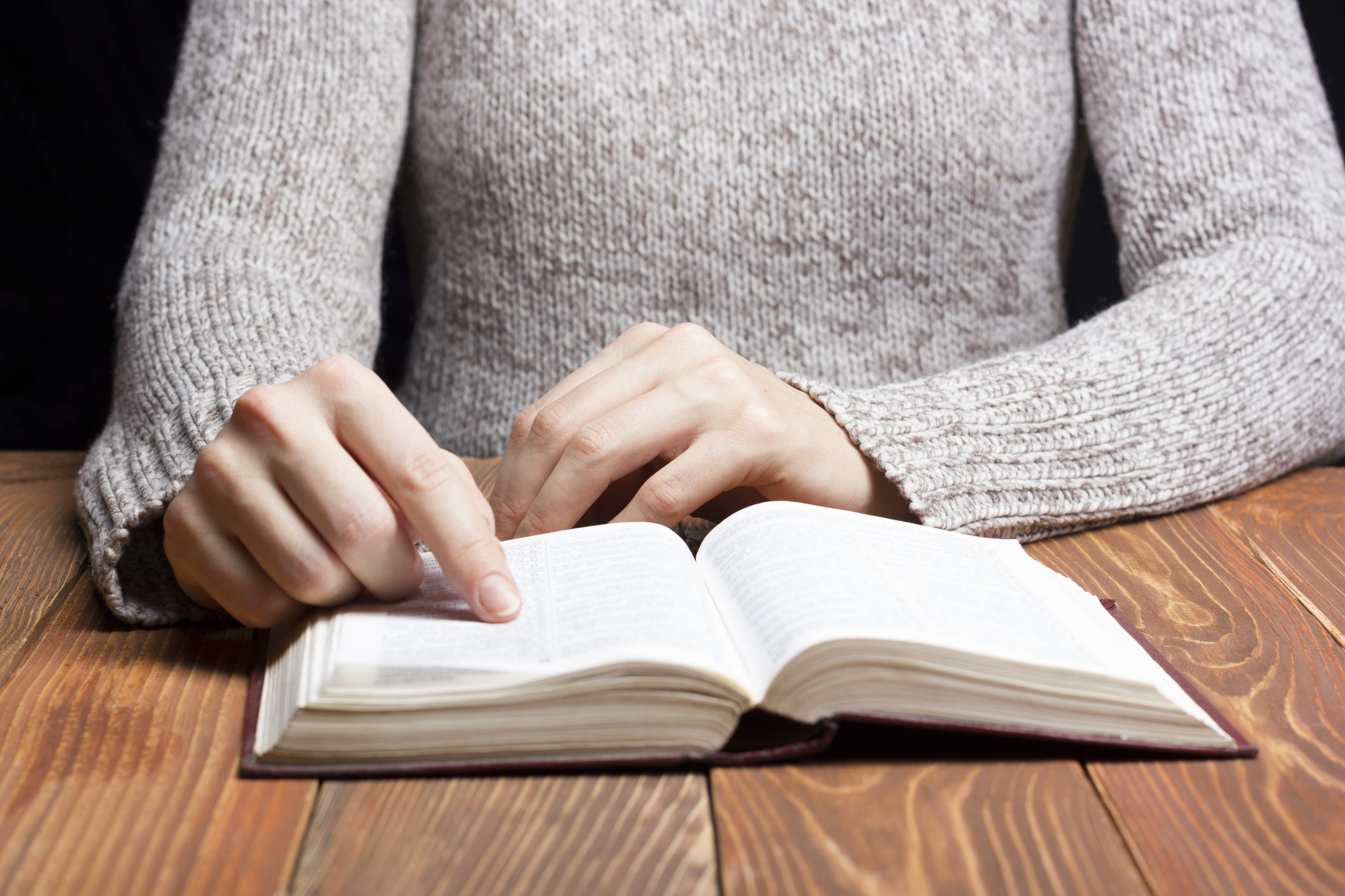 Closeup woman hand  holding pocket book to read.